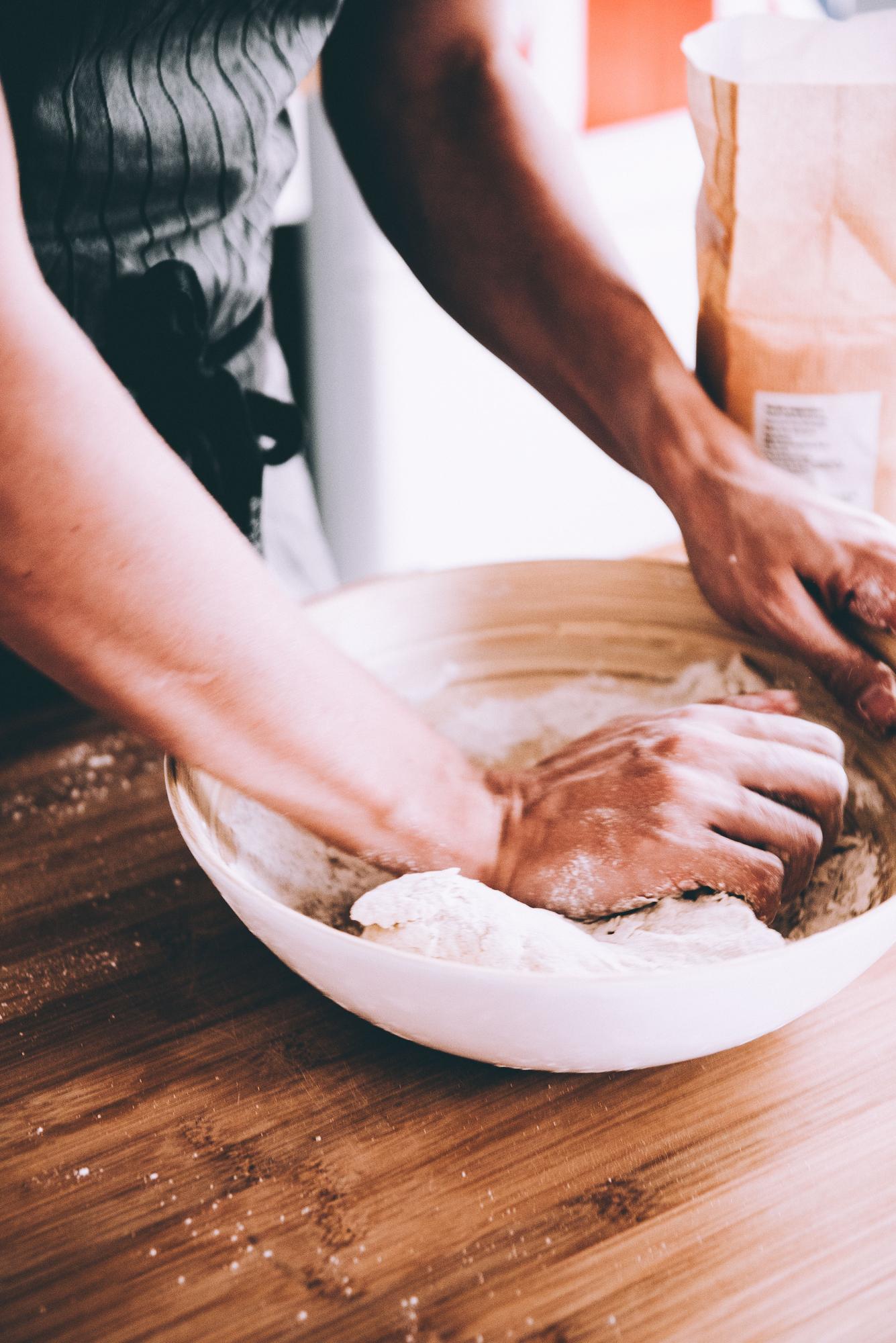 Dettaglio di mani che impastano in cucina